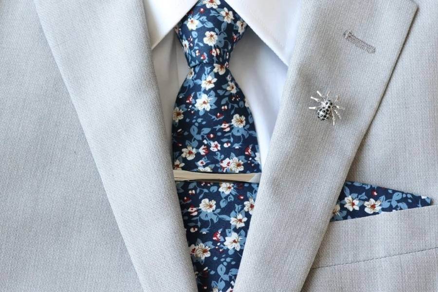 Costume gris clair et cravate bleue à motifs floraux