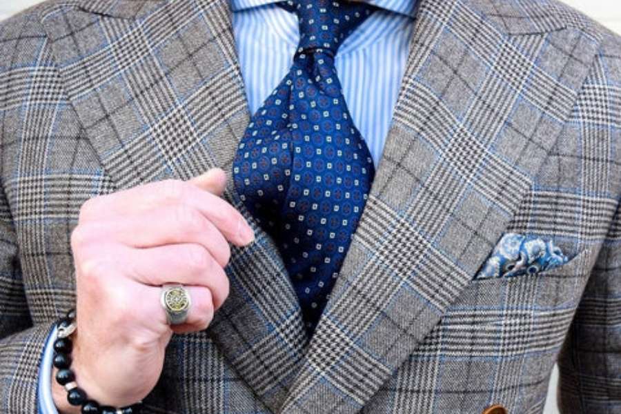 Costume à carreaux gris moyen et cravate à motifs bleus