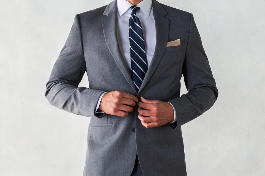 Costume gris moyen et cravate à rayures bleues