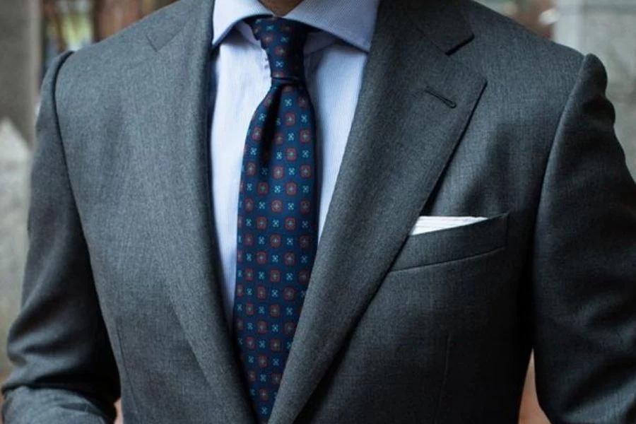 Costume gris anthracite et cravate bleue à motifs géométriques