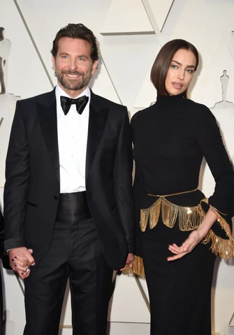 Lors de la cérémonie des Oscars, Bradley Cooper incarne parfaitement le style "Black Tie" dans un smoking noir ajusté, rehaussé par un cummerbund en soie qui souligne sa taille avec élégance. Aux côtés d'Irina Shayk, l'acteur démontre comment cet accessoire traditionnel complète le nœud papillon et les revers en pointe pour créer un look formel impeccable. Cette apparition sur le tapis rouge illustre l'importance du cummerbund pour maintenir une esthétique épurée et sophistiquée, typique des événements les plus prestigieux de Hollywood.